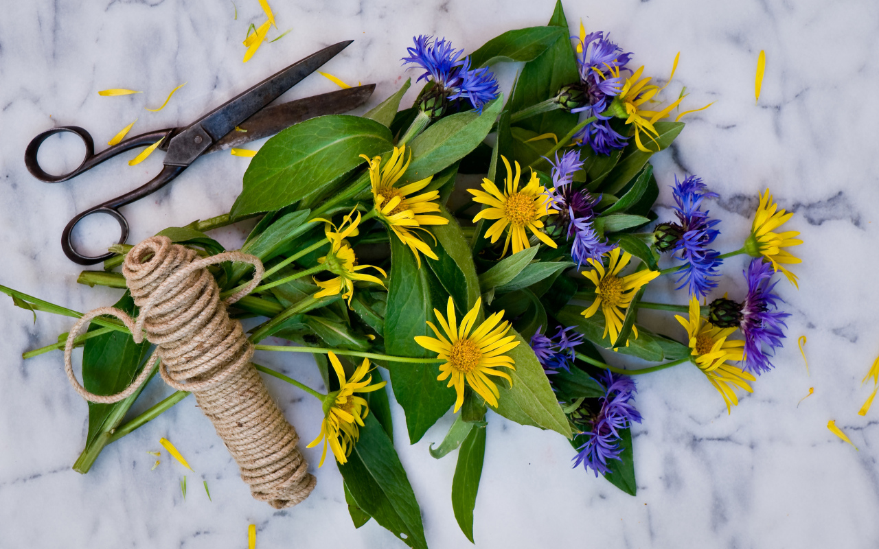 Букет васильков с желтыми цветами на столе с веревкой и ножницами