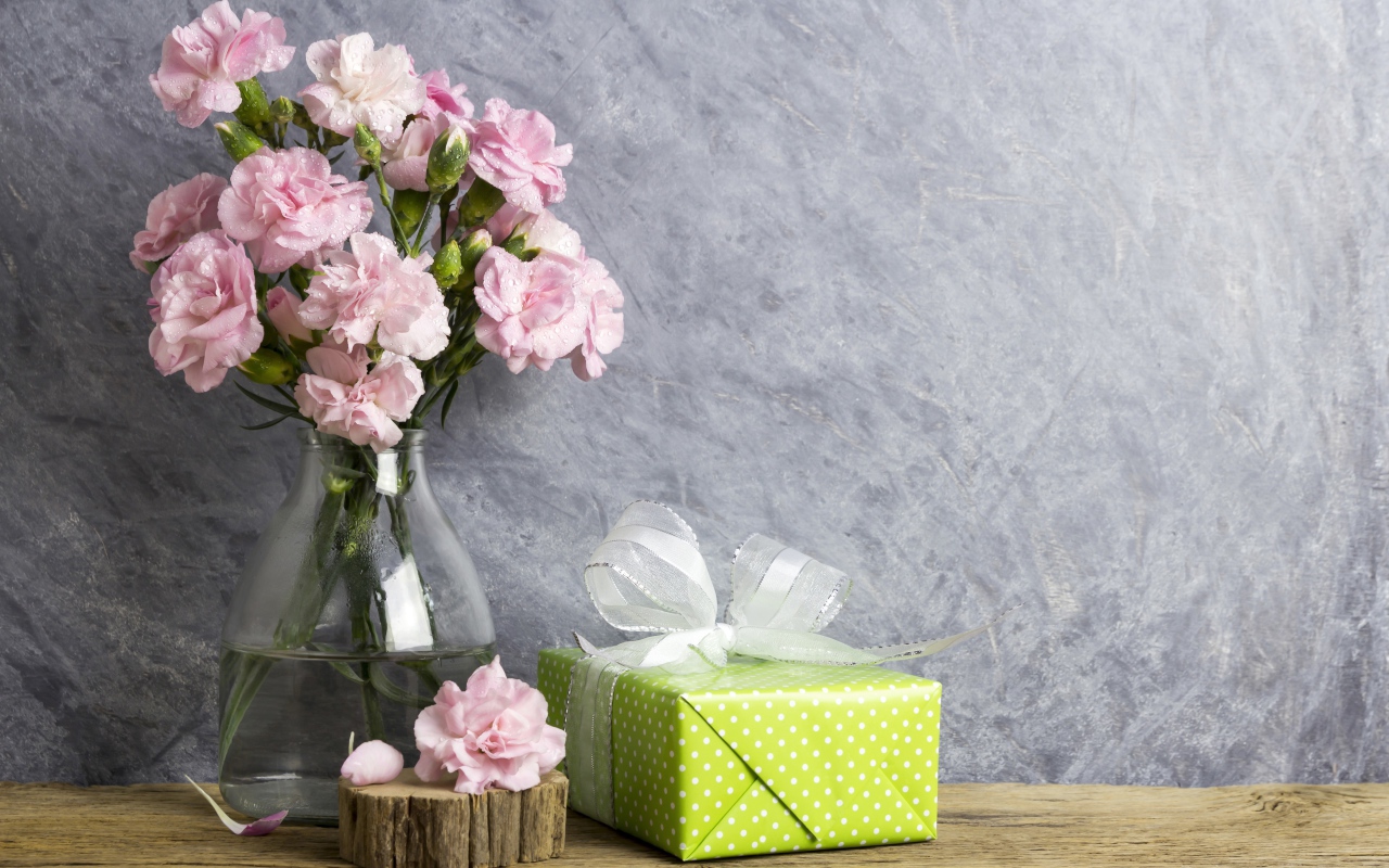 Розовые гвоздики с подарком на сером фоне