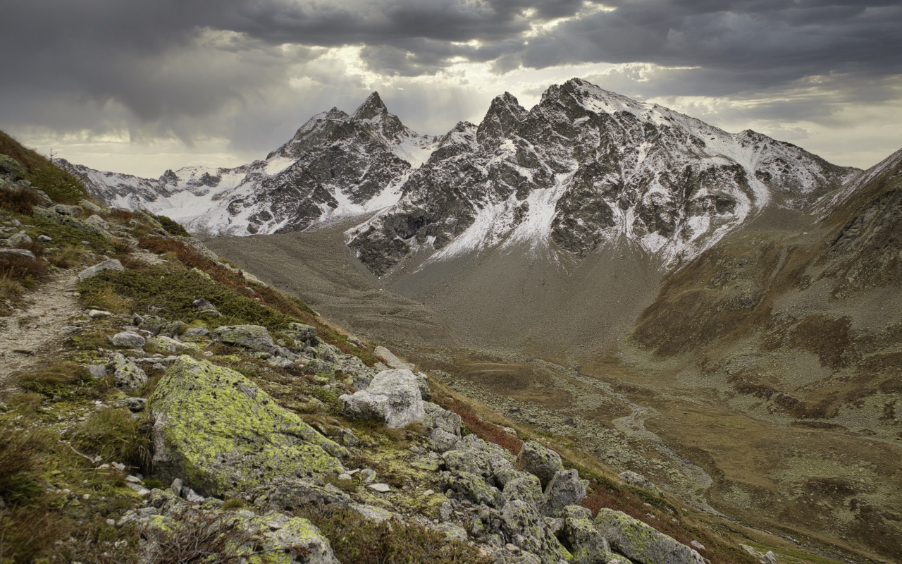 Высохшая река в горах под грозовым небом