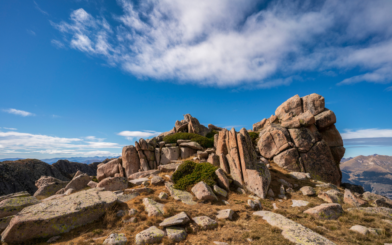 Каменные горы под голубым небом с белыми облаками 
