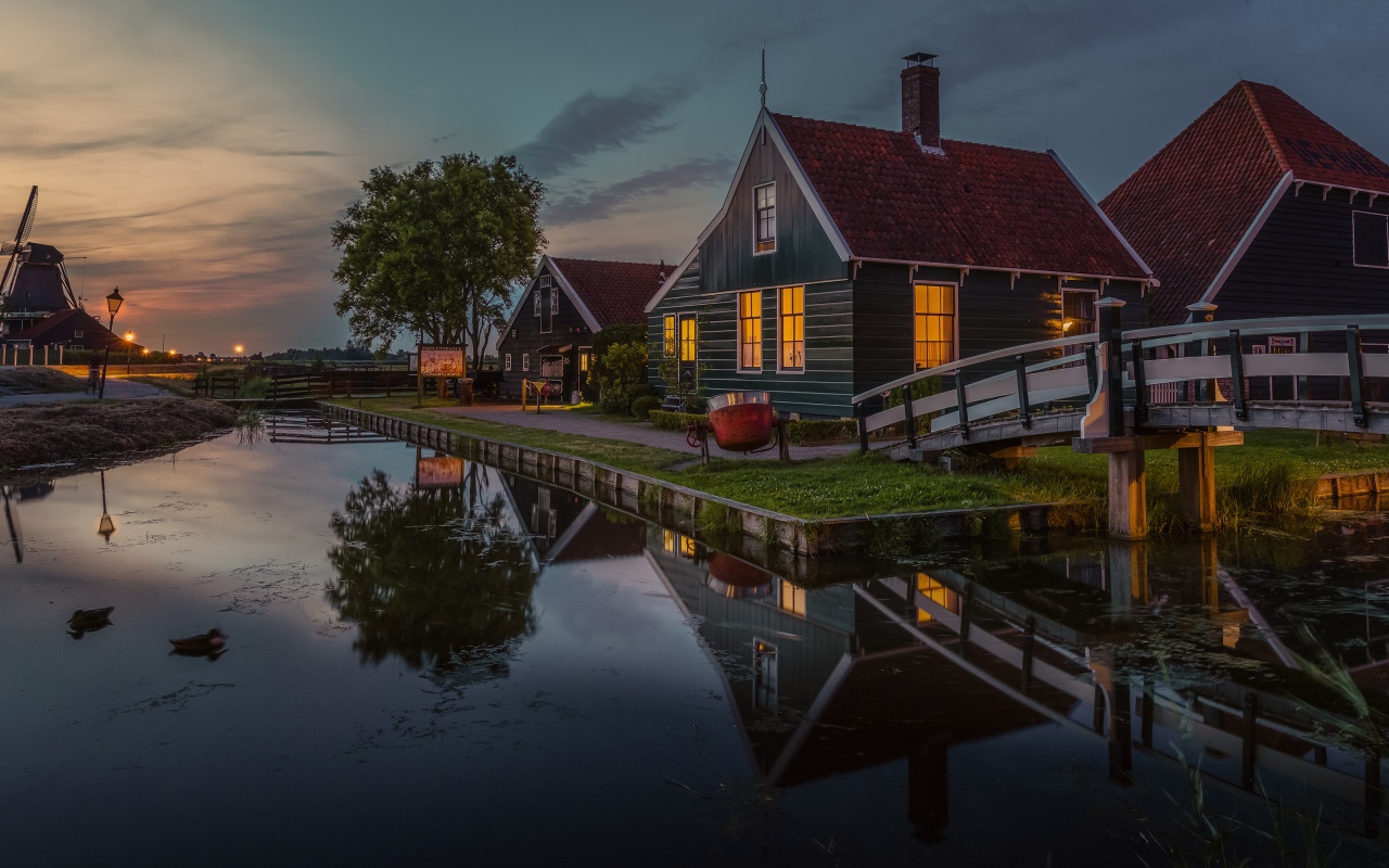 Маленькие дома у пруда вечером 