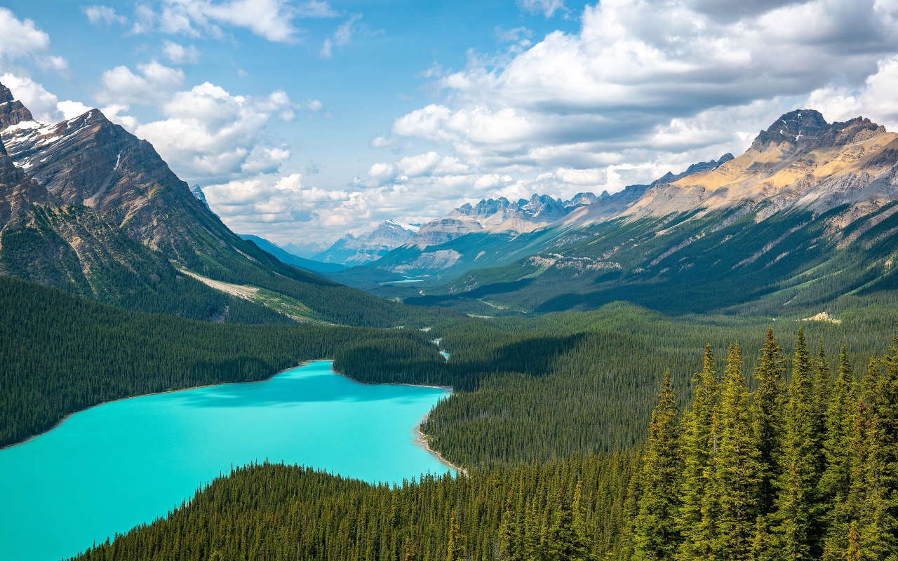 View of a beautiful blue lake and mountain valley under a sunny sky with white clouds