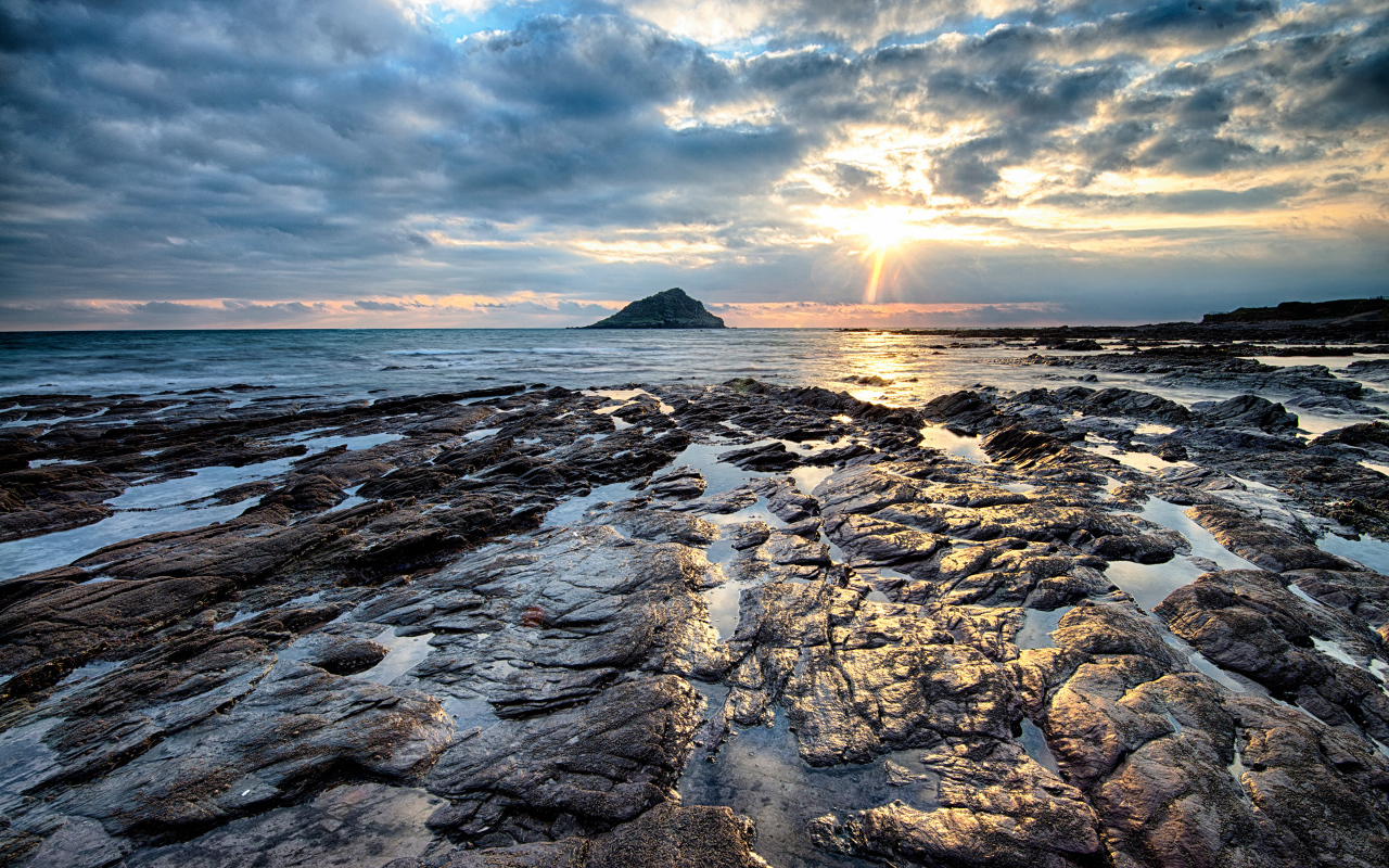 Каменный берег океана в лучах солнца