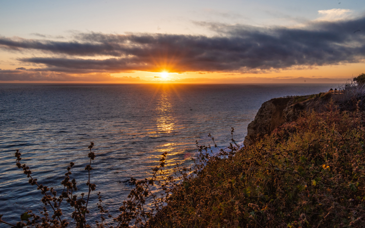 Вид на закат солнца в темных облаках в небе над морем 