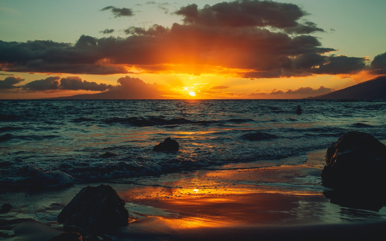 Мокрый песок на берегу океана на закате