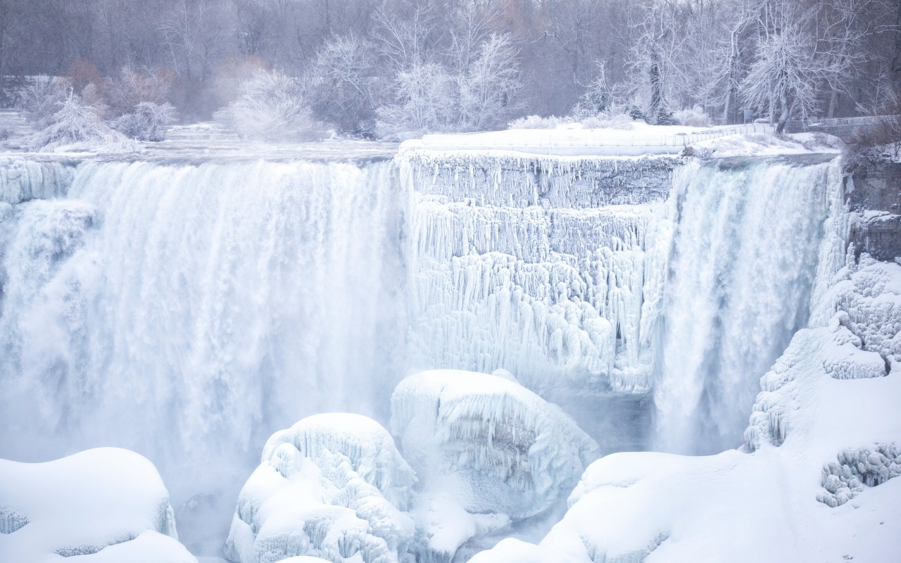 Замерзший водопад стекает по камням зимой