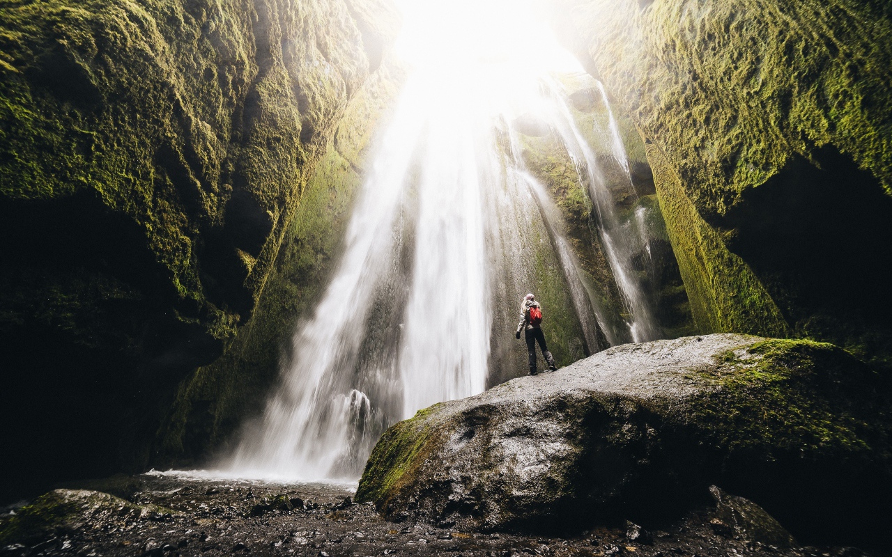 Быстрый водопад стекает между скал 