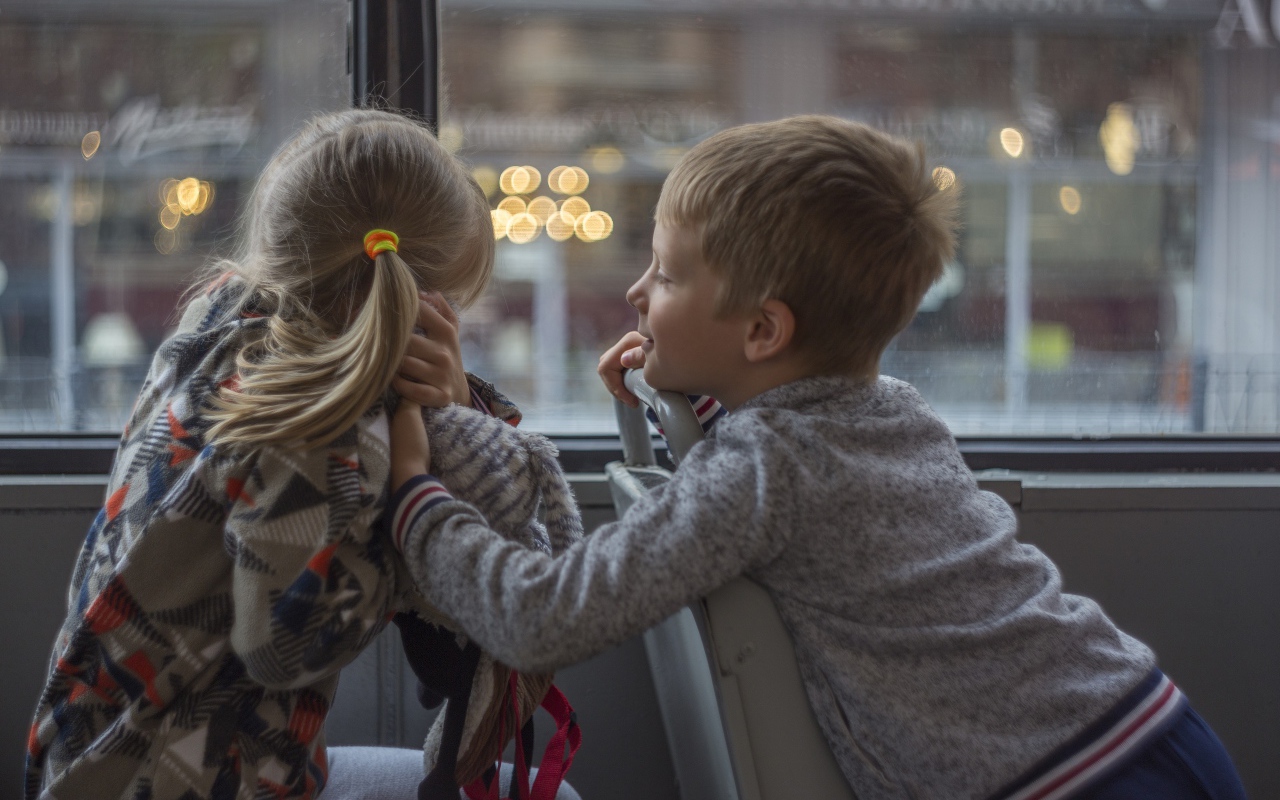 Маленькие девочка и мальчик сидят в автобусе 