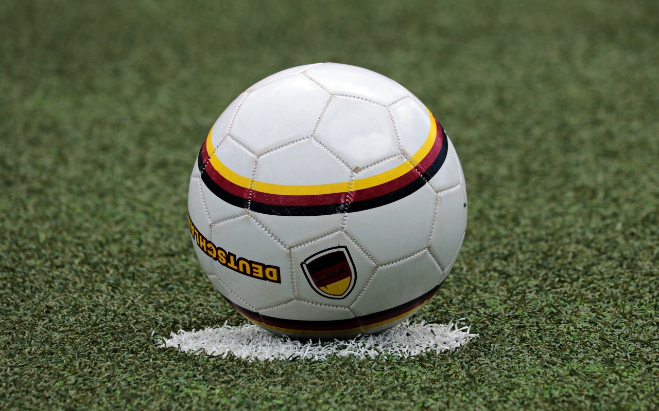 Футбольный мяч лежит на метке на поле 