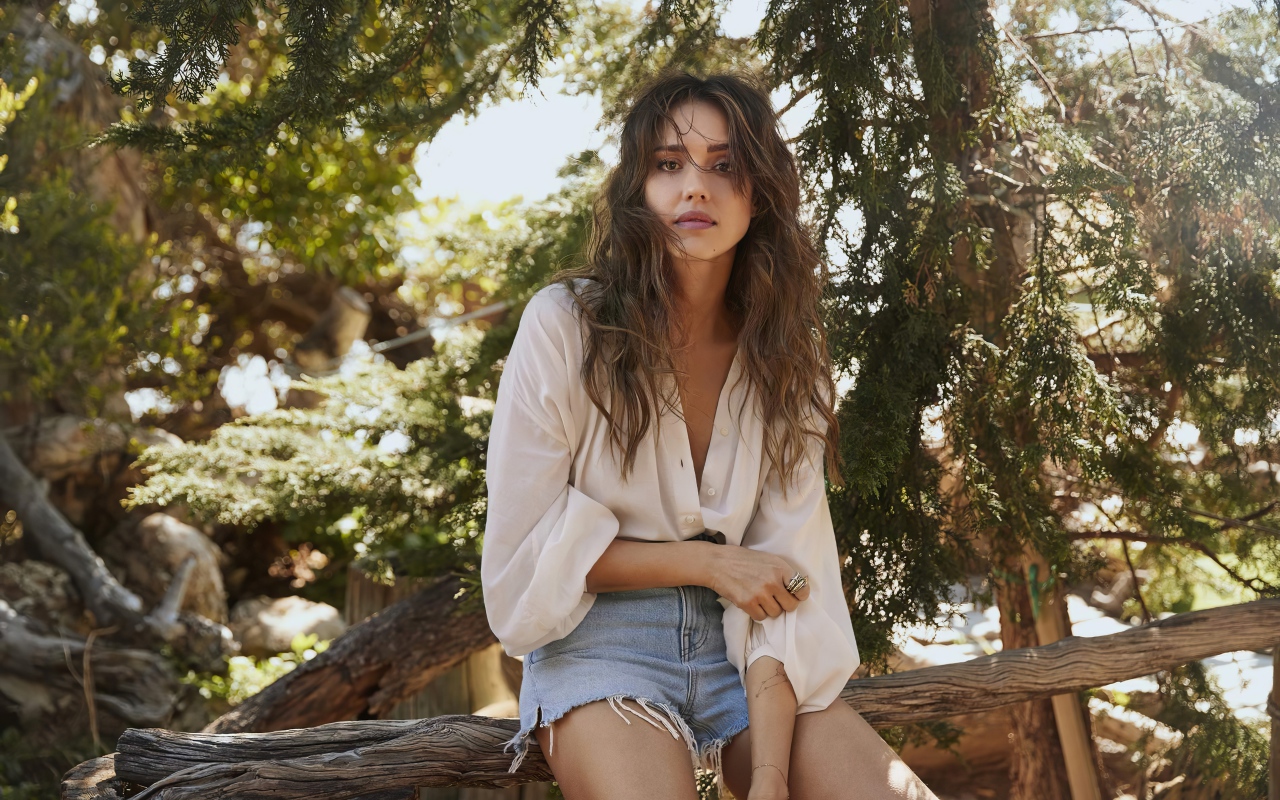 Актриса Джессика Альба сидит на сухом дереве 