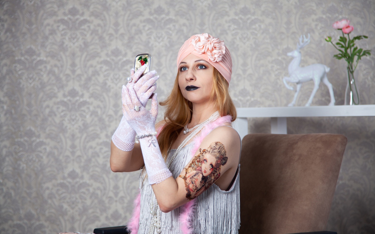 Красивая ретро девушка с татуировкой на руке