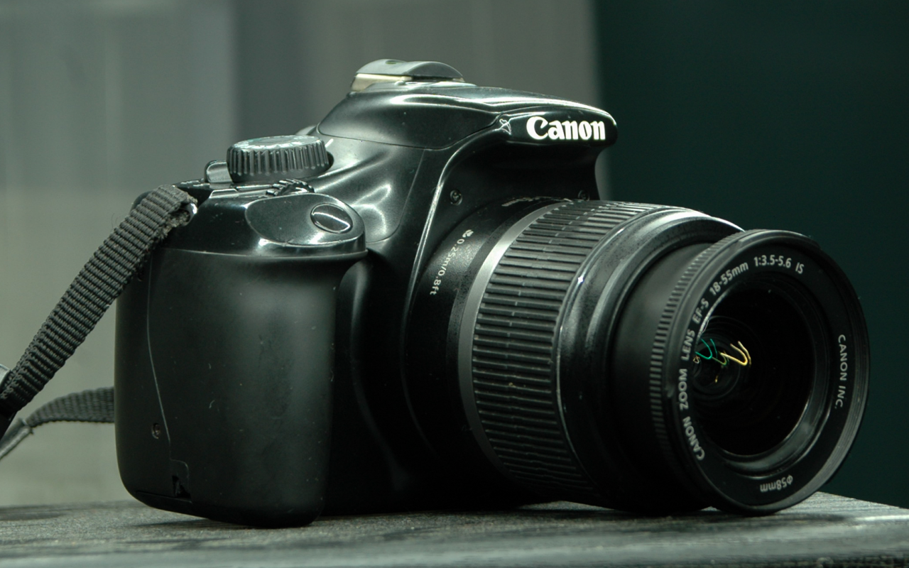 Фотоаппарат Canon 1100D лежит на столе