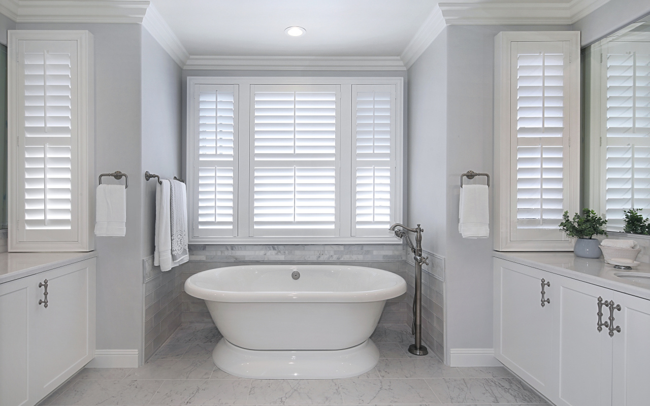 Большая белая ванна в комнате с окнами