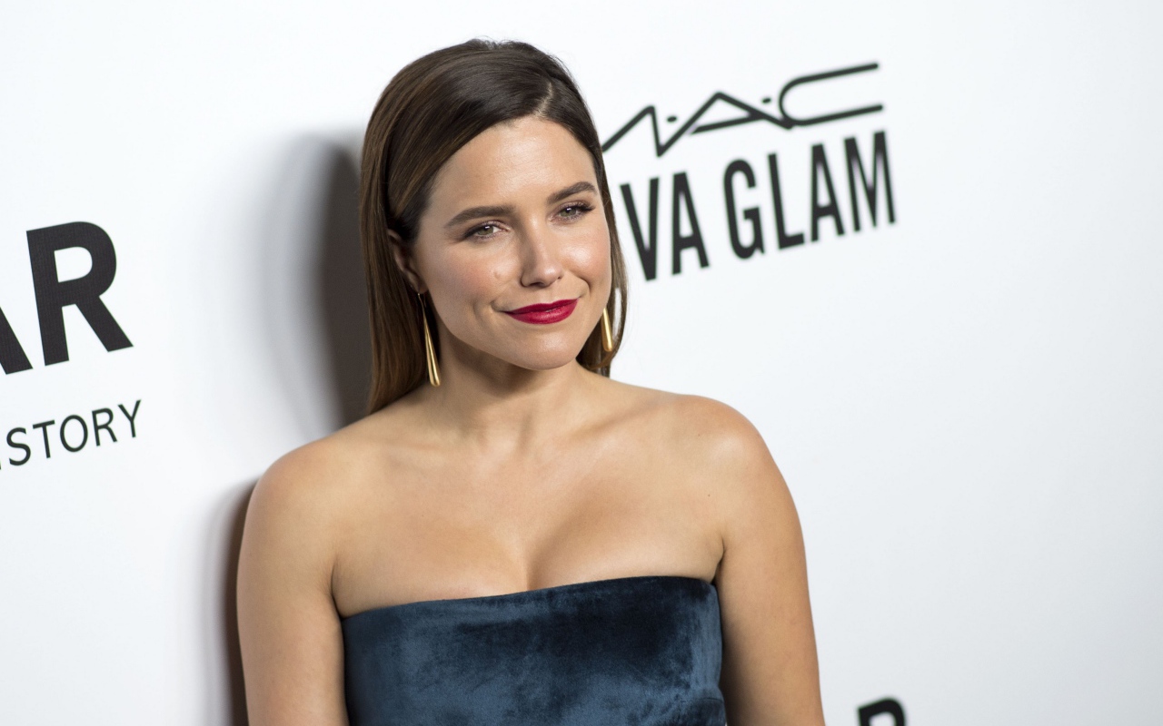 Улыбающаяся женщина, актриса София Буш у стены