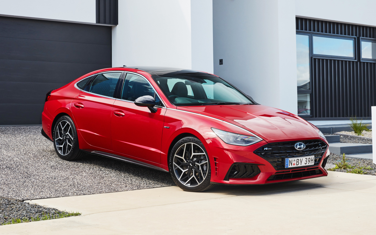 Красный автомобиль Hyundai Sonata N Line 2021 года у гаража