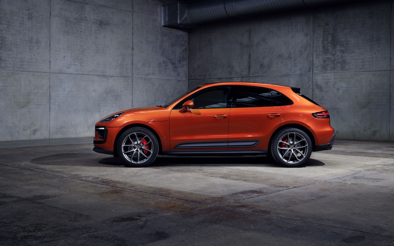 Оранжевый Porsche Macan S 2021  года на сером фоне