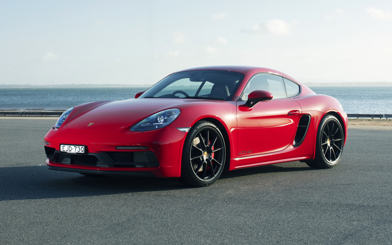 Красный автомобиль Porsche 718 Cayman GTS у моря