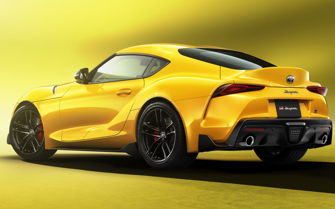 Желтый автомобиль Toyota GR Supra SZ-R, 2022 года  на желтом фоне