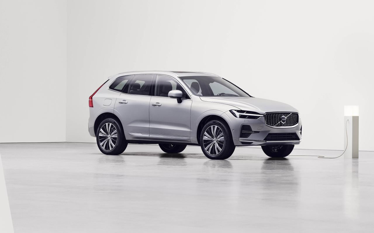 Серебристый электромобиль Volvo XC60 T8 Recharge AWD, 2021 года на заправке