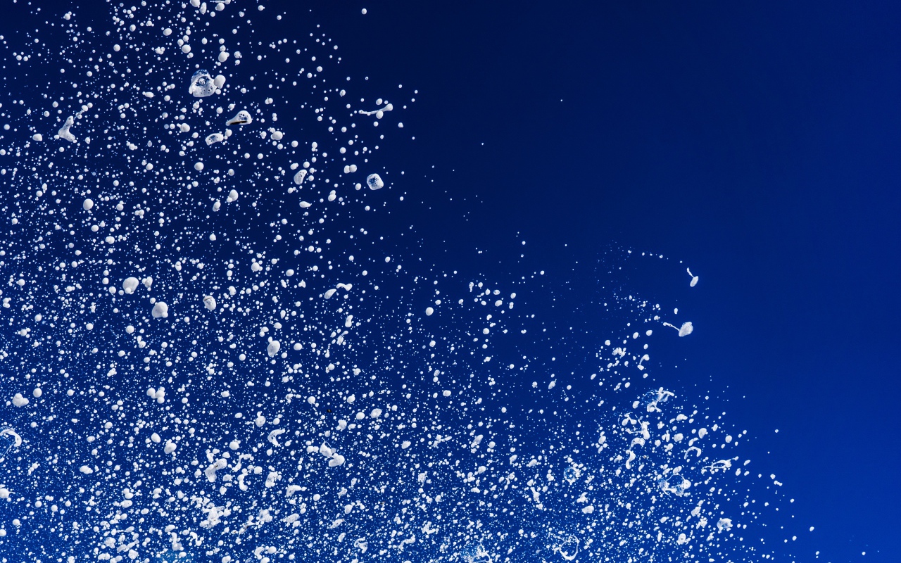 Белые брызги воды на синем фоне 
