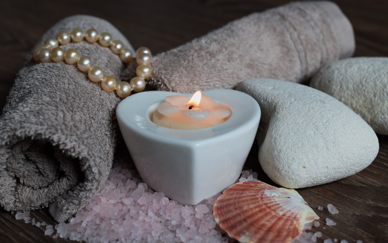 Красивая свеча с полотенцем, бусами, камнями и морской солью