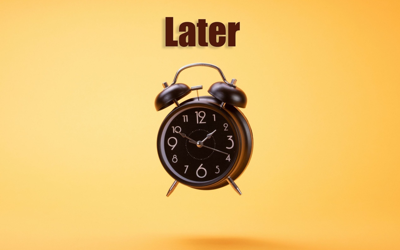 Большой черный будильник на желтом фоне 