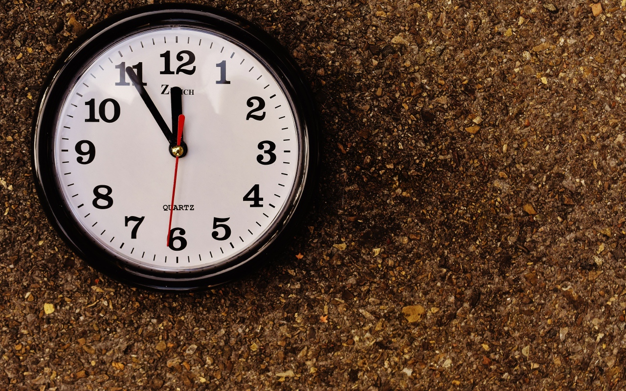 Большие черные часы висят на стене 