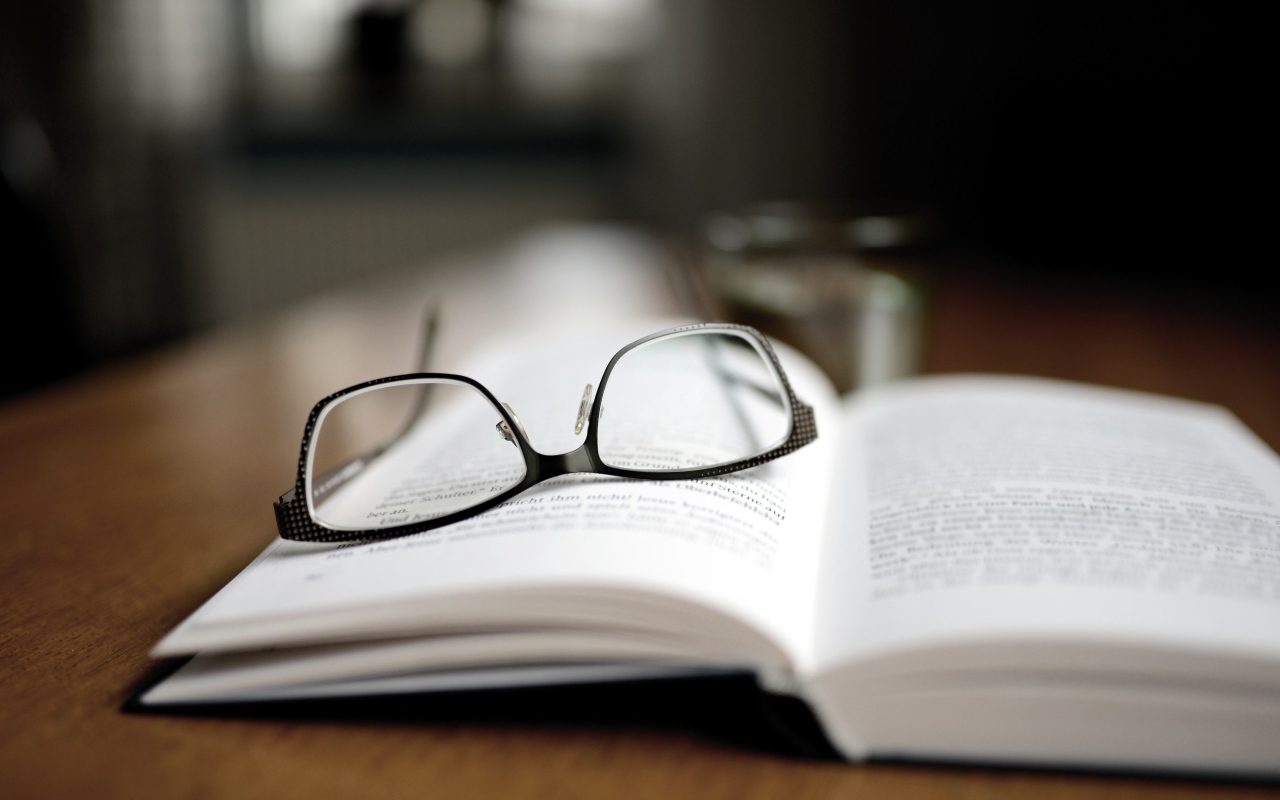 Черные очки лежат на книге 