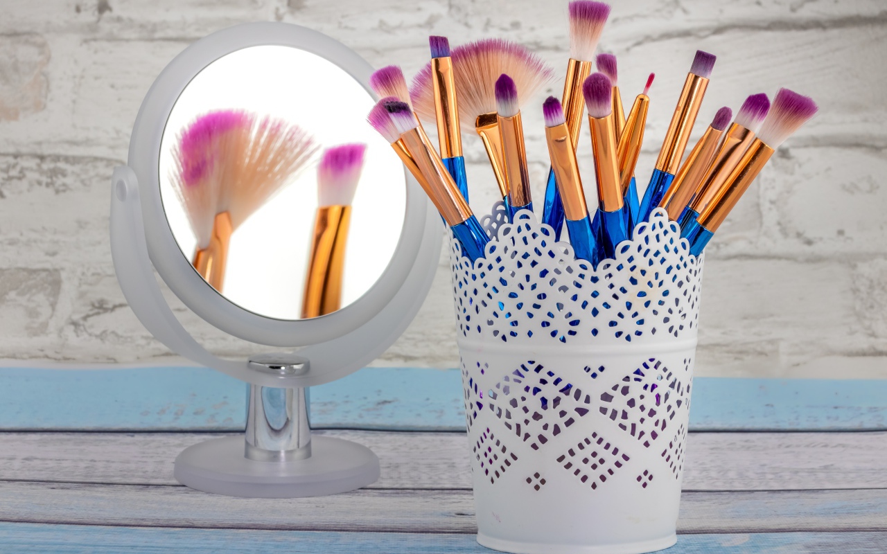Кисточки для макияжа на столе с зеркалом