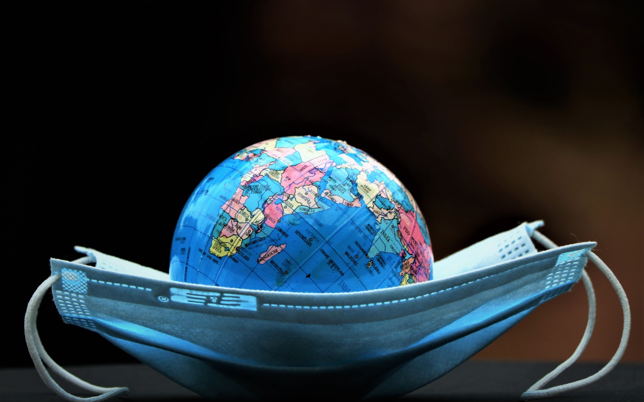 Медицинская маска и глобус на черном фоне