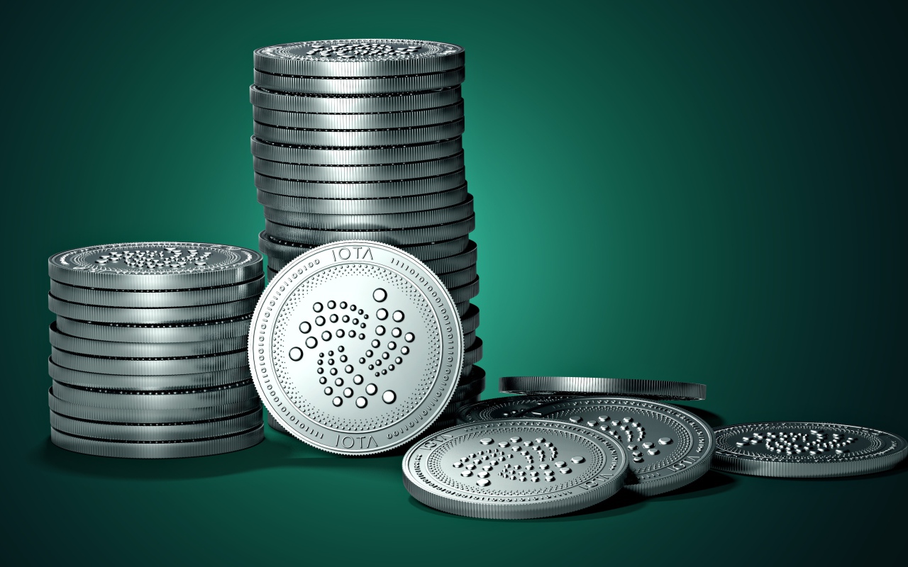 Монеты IOTA на зеленом фоне