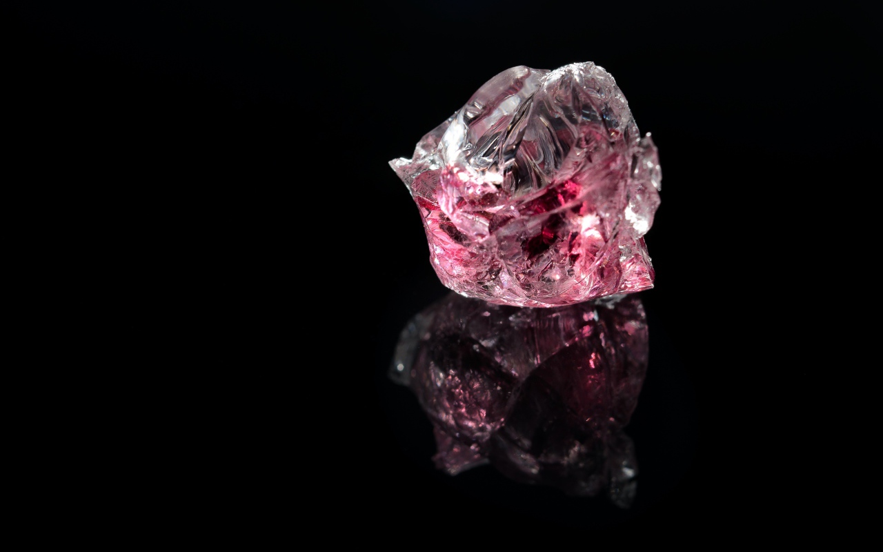 Розовый драгоценный камень на черном фоне 