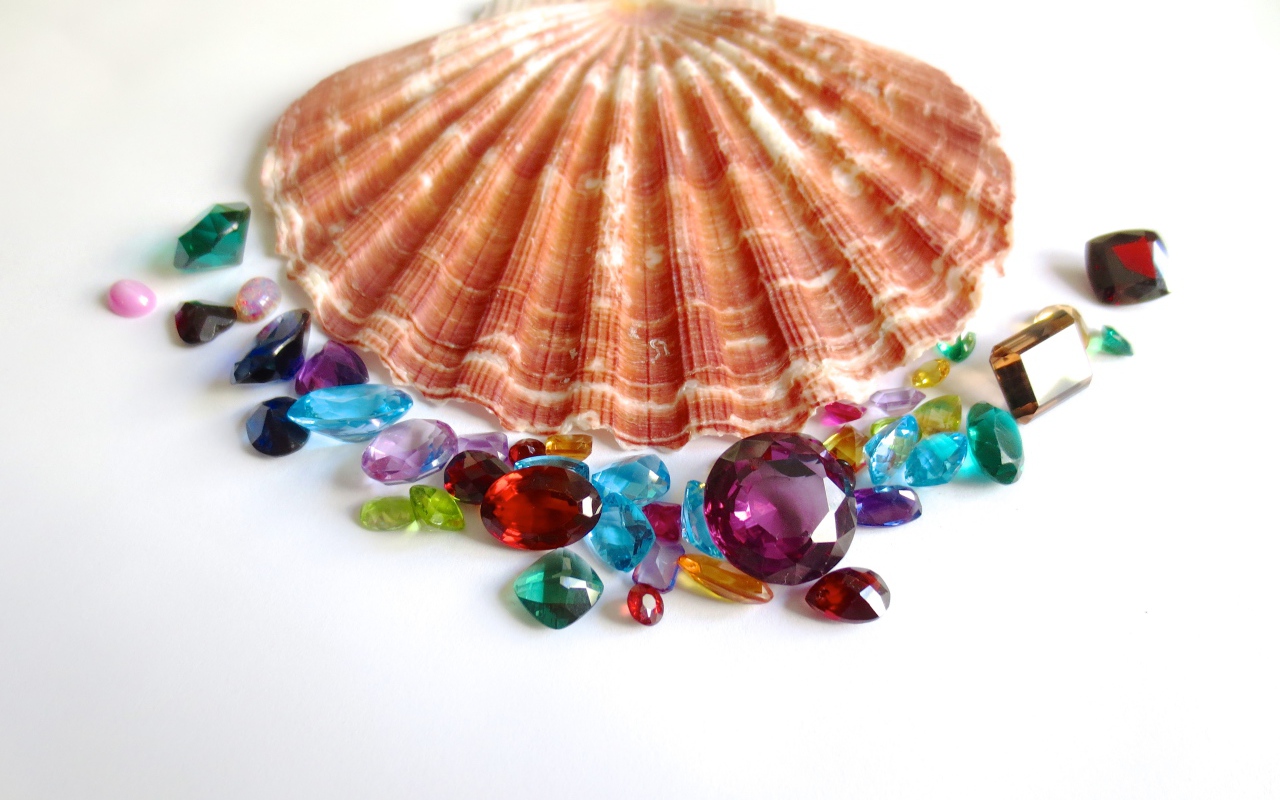 Ракушка и драгоценные камни на белом фоне