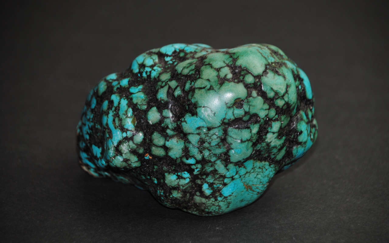 Драгоценный камень бирюзы на сером фоне