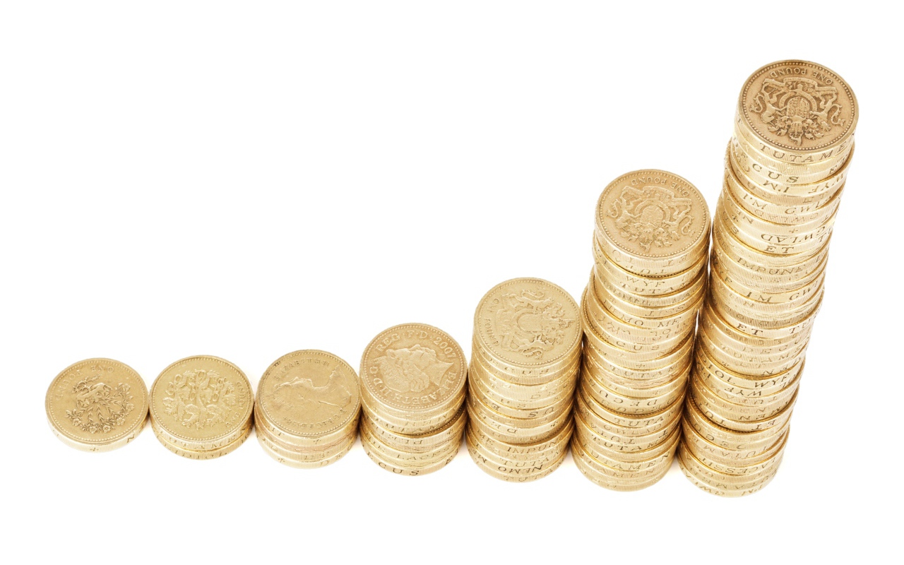 Стопки золотых монет на белом фоне