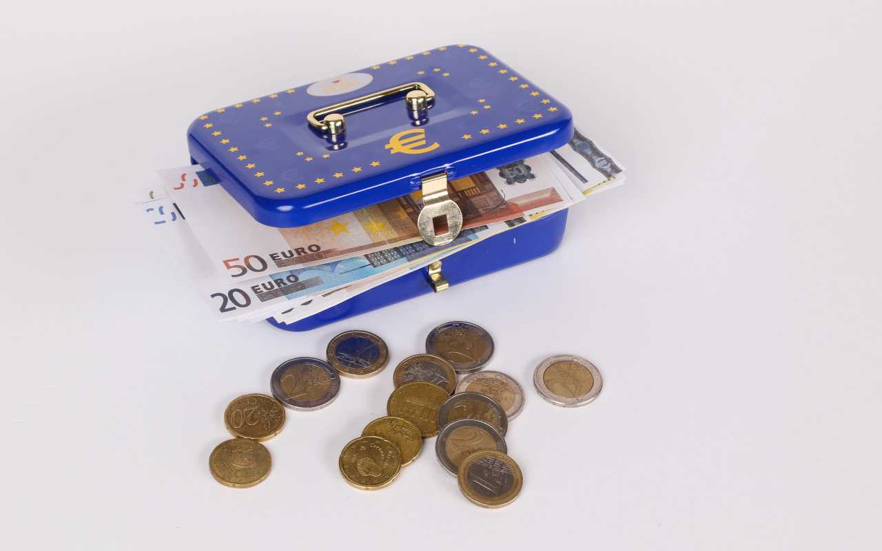 Синяя копилка чемодан с деньгами и монетами на сером фоне