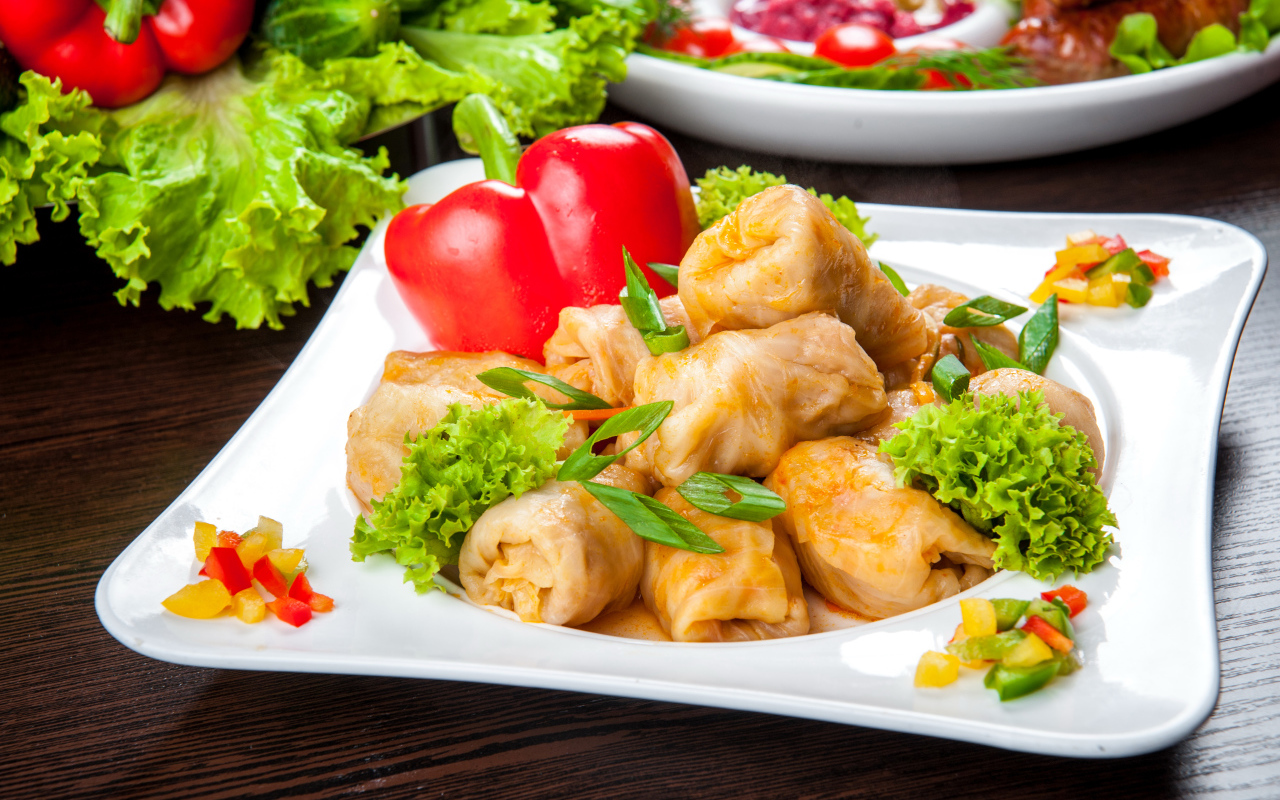 Аппетитные голубцы на тарелке с перцем 