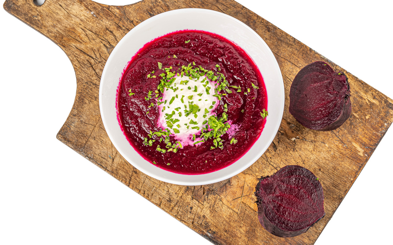 Свекольный суп в тарелке на белом фоне