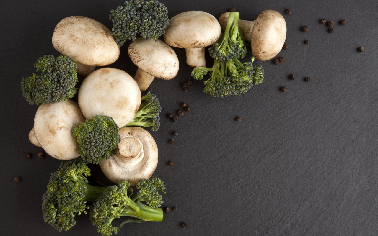 Шампиньоны с брокколи на сером столе 