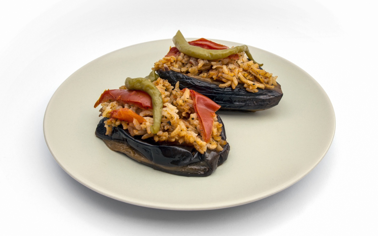 Блюдо из баклажанов с рисом на большой белой тарелке