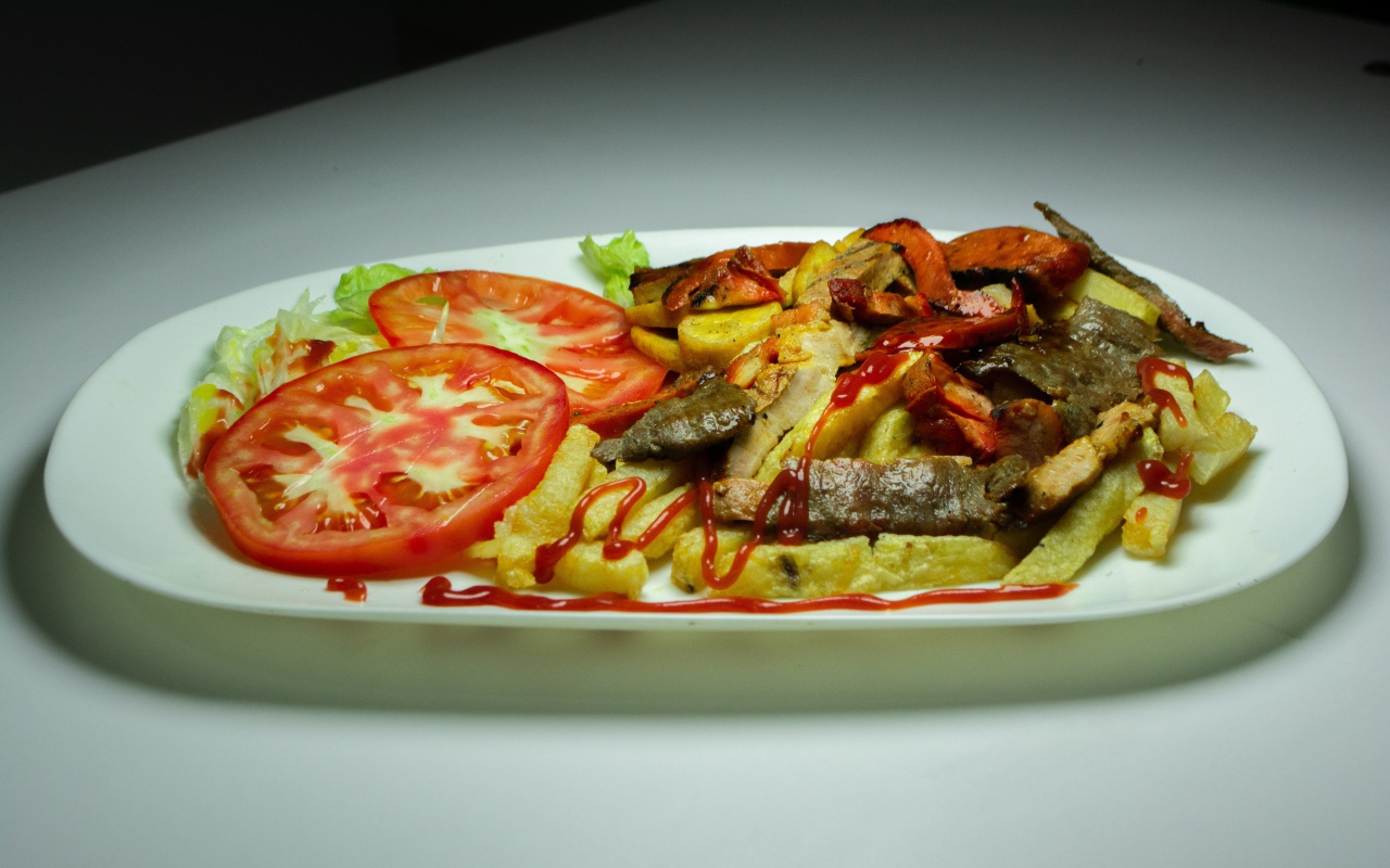 Картофель фри на тарелке с помидорами 