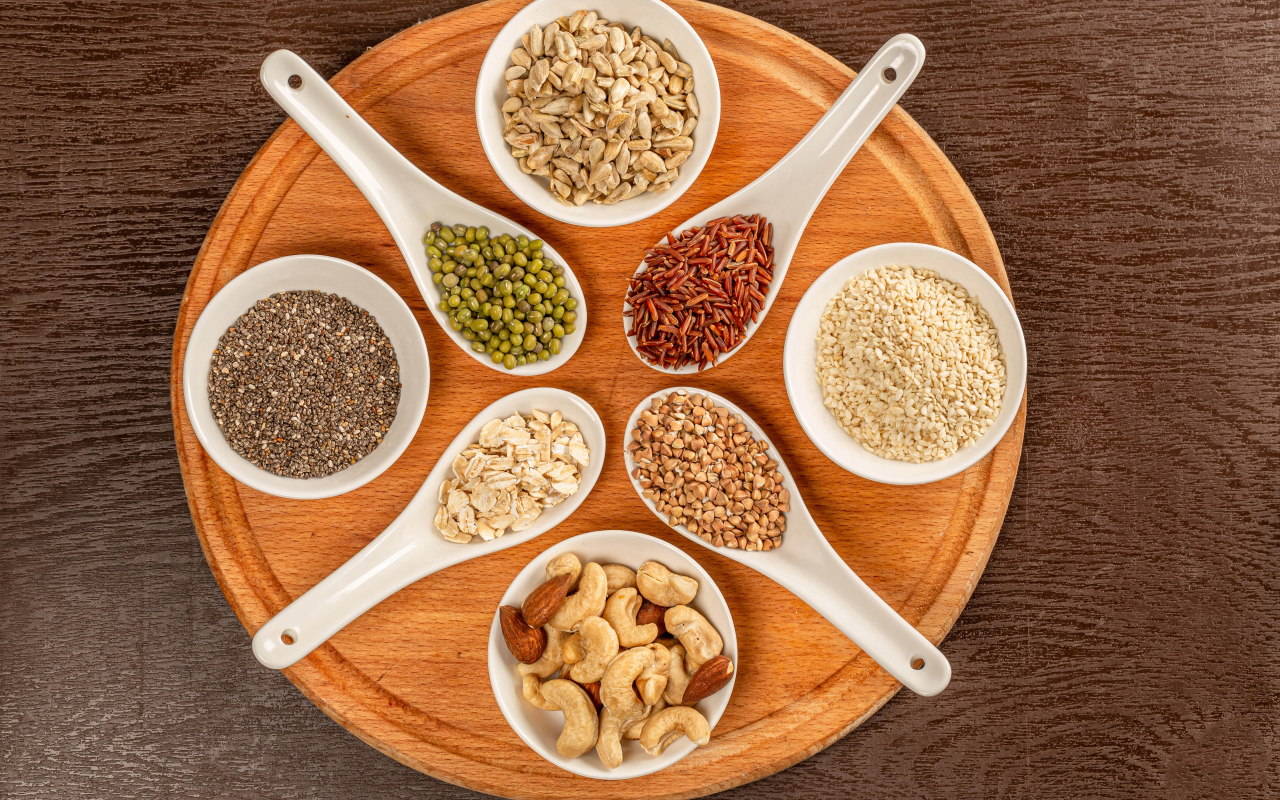 Зерна и орехи на доске на столе 