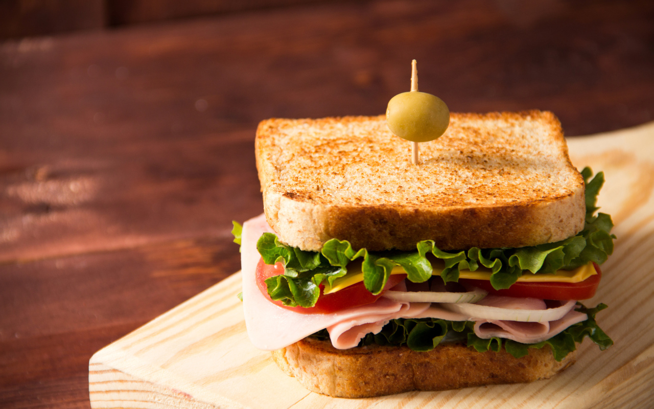 Гамбургер с ветчиной, помидорами, листьями салата и сыром