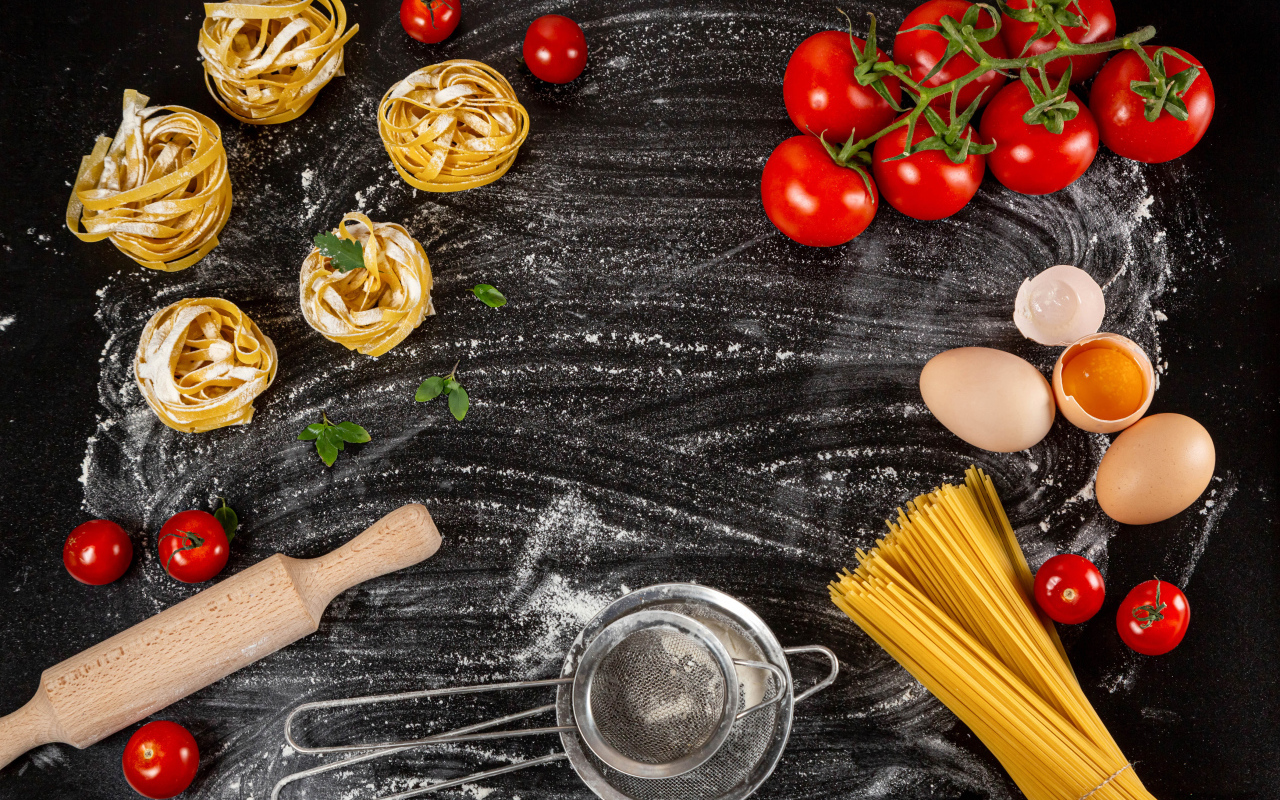 Паста с помидорами и яйцами на черном столе 
