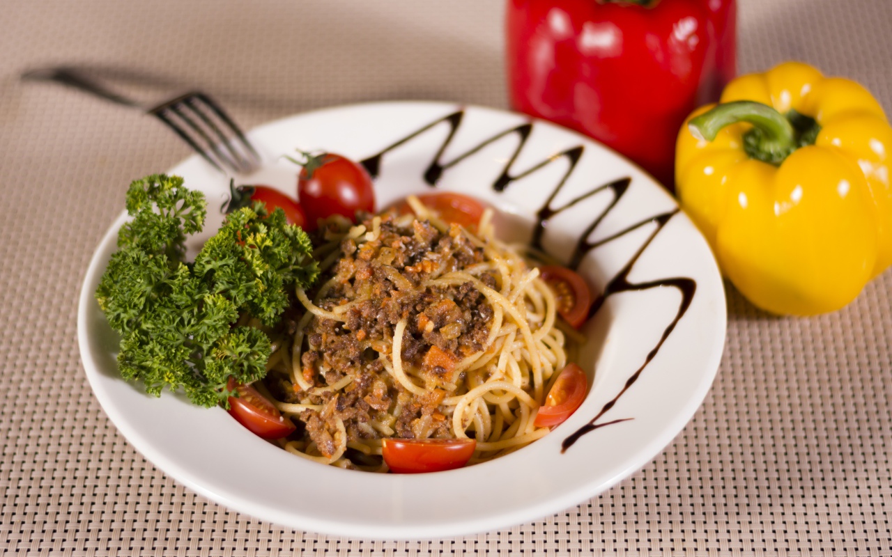 Спагетти с фаршем и помидорами в тарелке 