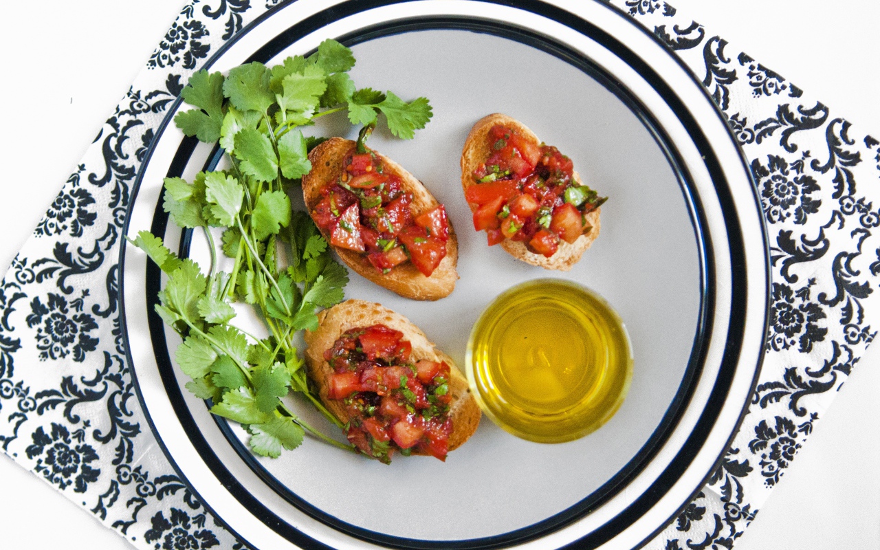 Бутерброды с помидорами на тарелке с петрушкой и маслом