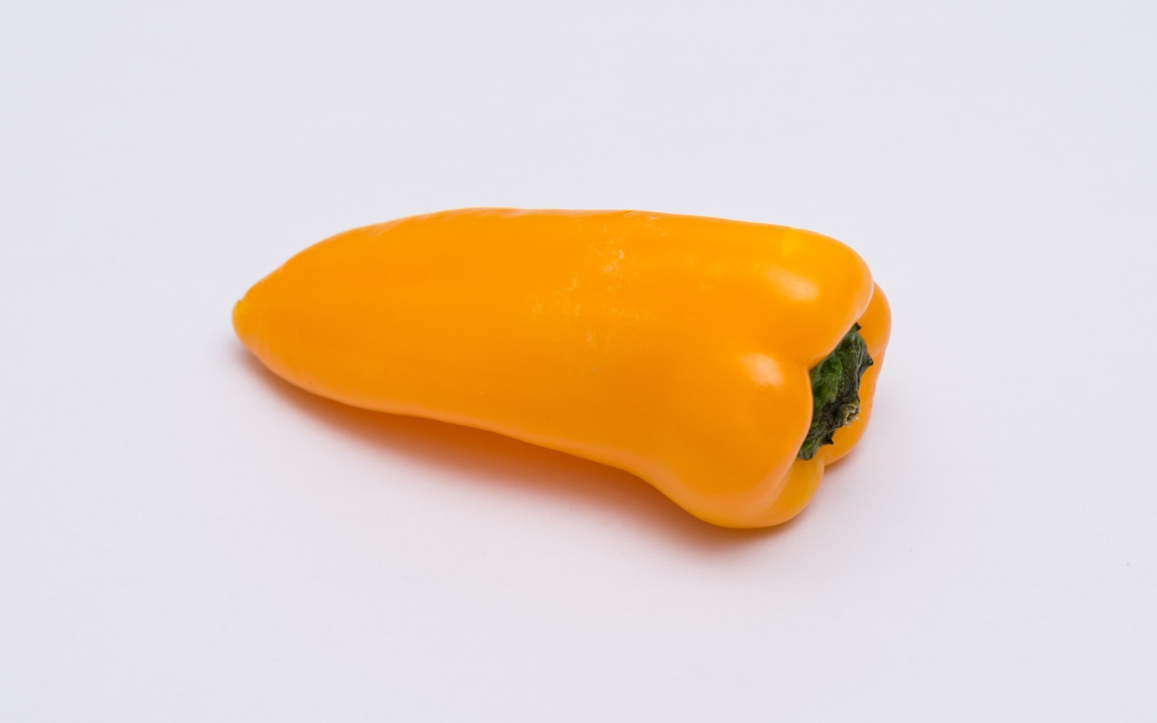 Желтый болгарский перец на сером фоне