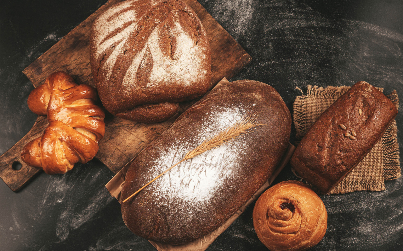 Свежий хлеб и булочки на разделочной доске