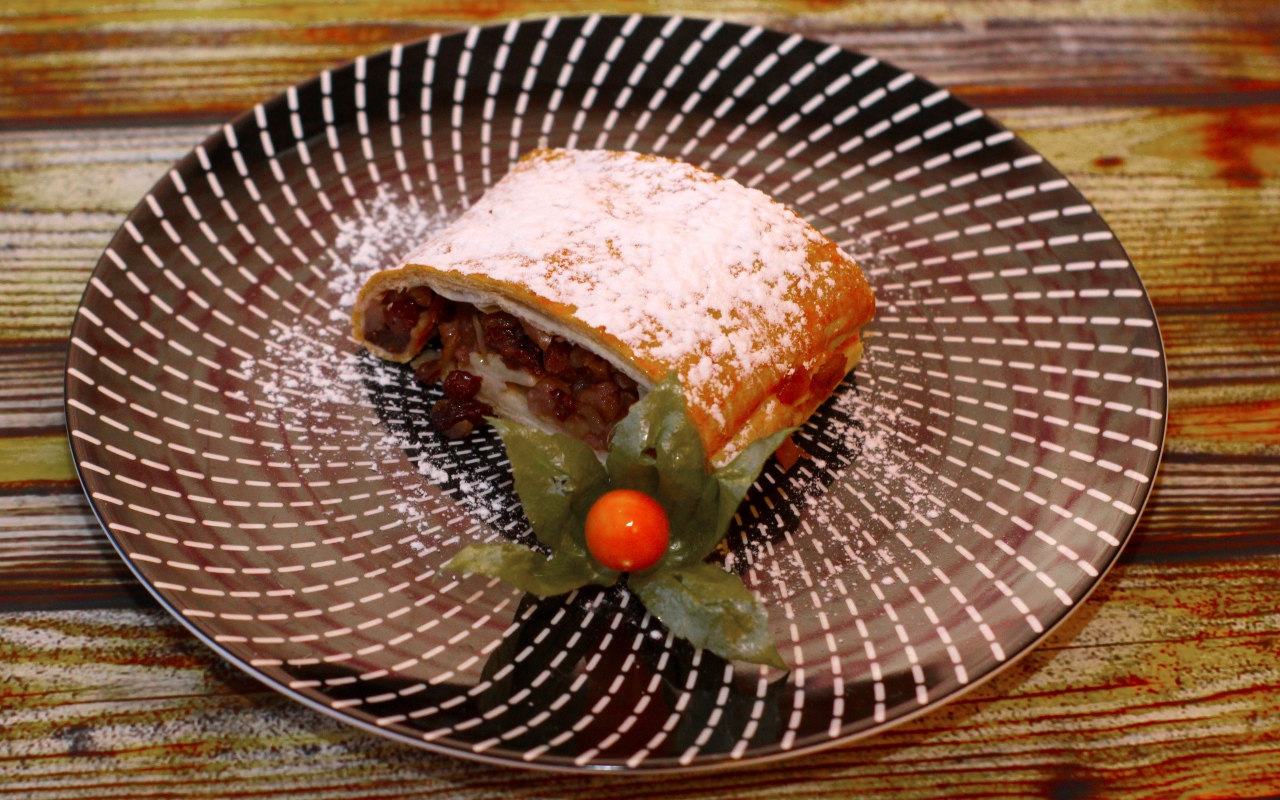 Кусок яблочного штруделя на тарелке 