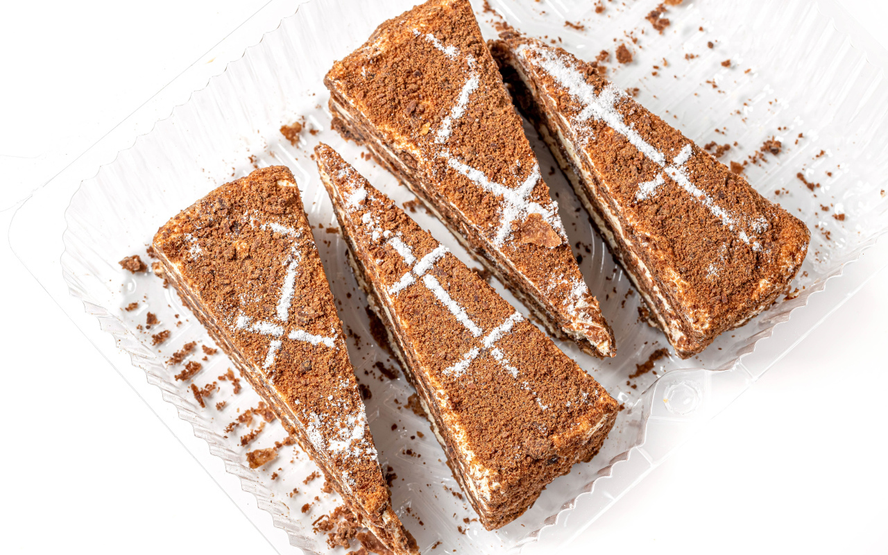 Куски аппетитного медового торта на белом фоне